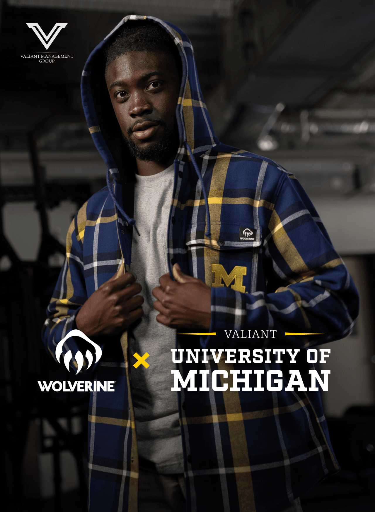 Wearing a Maize and blue plaid jacket with the Wolverine and University of Michigan logos on the breast pocket.