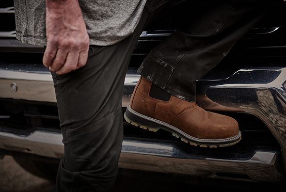 Brown boots climbing into a truck.