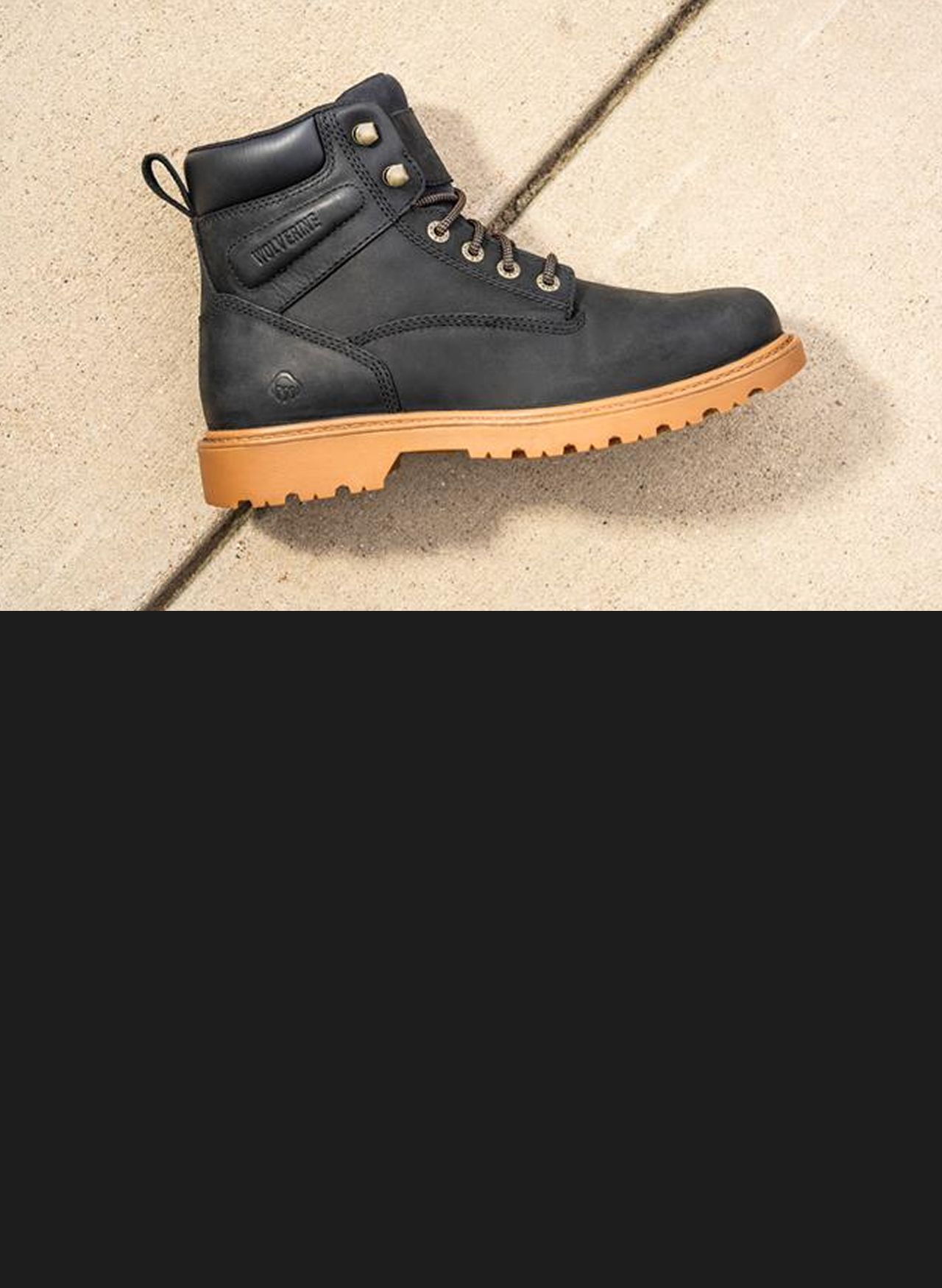 Black boot lying on concrete.