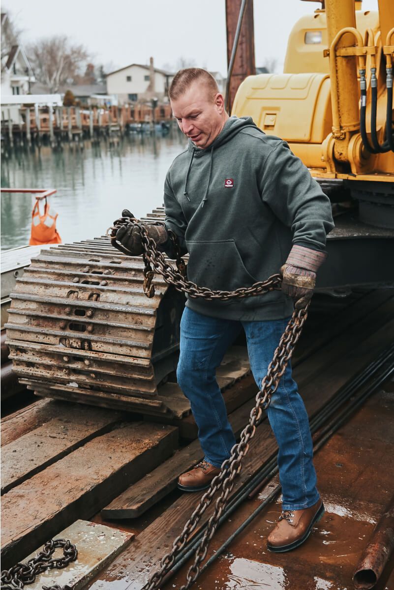 a man working at a dock holding a large chain