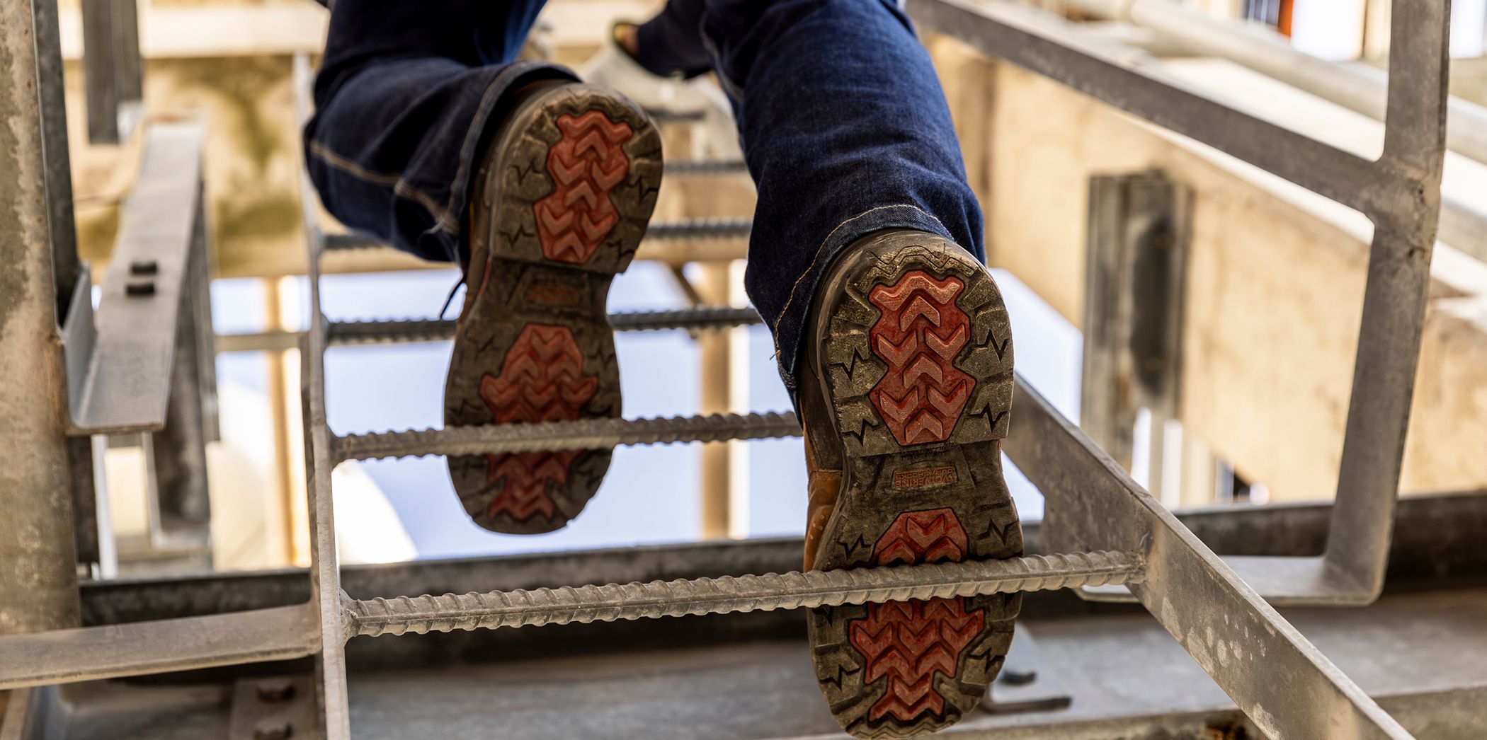Infinity System boots shown from below climbing a ladder.