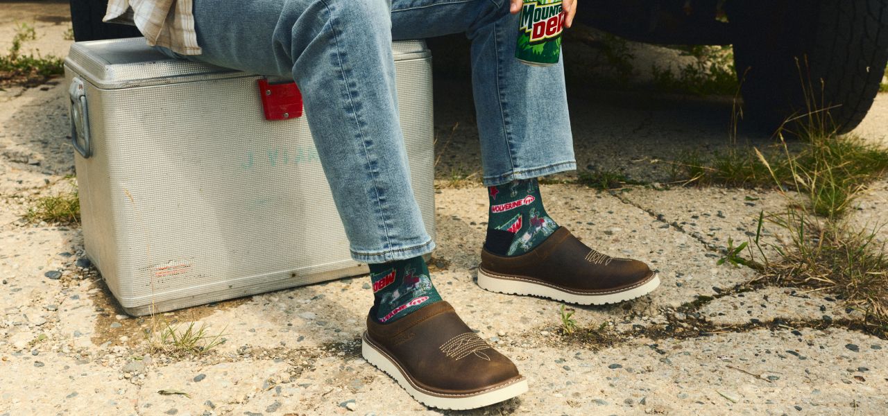Sitting on a cooler with brown shoes on the sand.