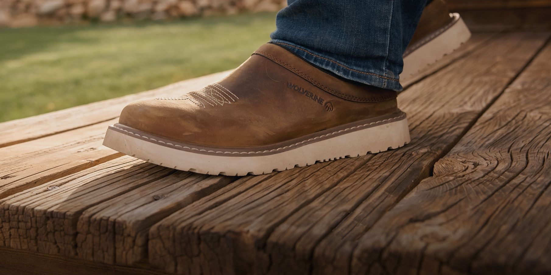 Men's Bronc Clog Slip-On Shoe on a worn wooden deck.