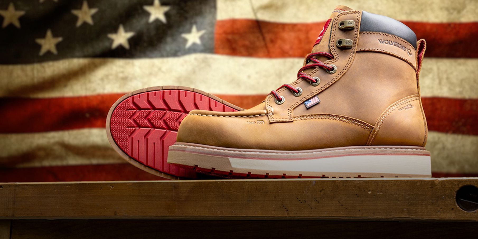 Brown boots on a bench with an American flag in the background.