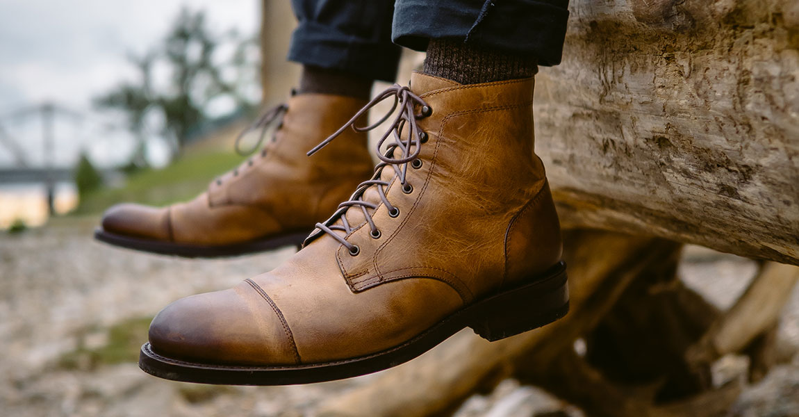 Wolverine BLVD Cap Toe in tan by a log.