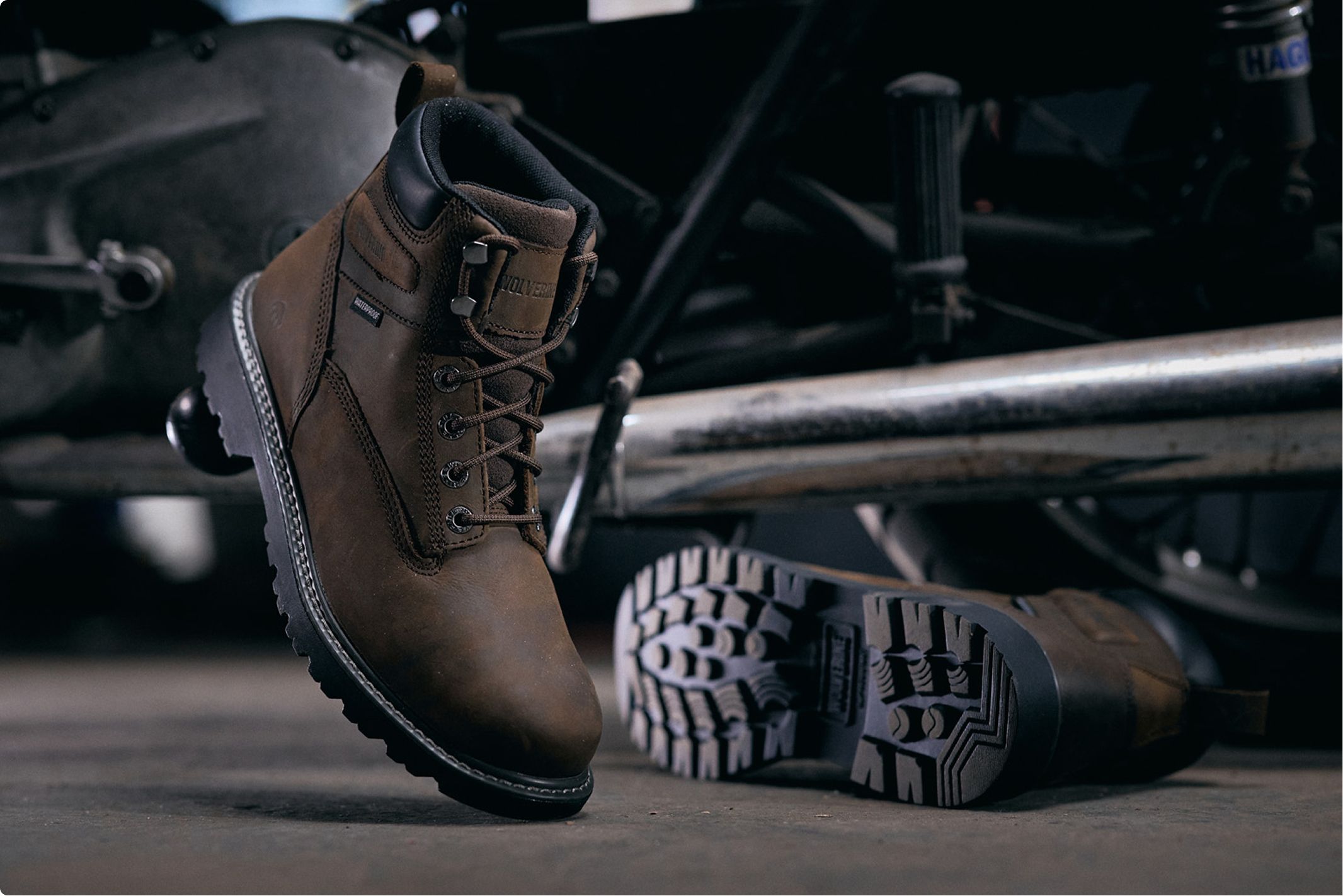 Brown Boots beside a motorbike.