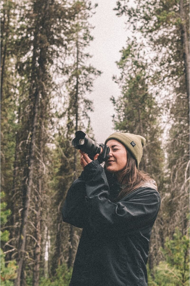 Person taking a picture in the woods