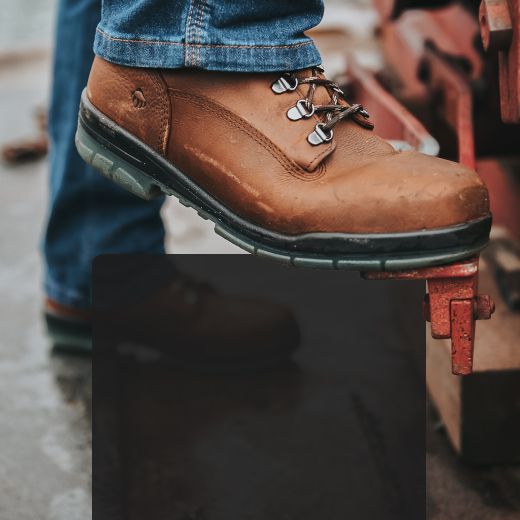 Boots pushing down on a metal footbrake.