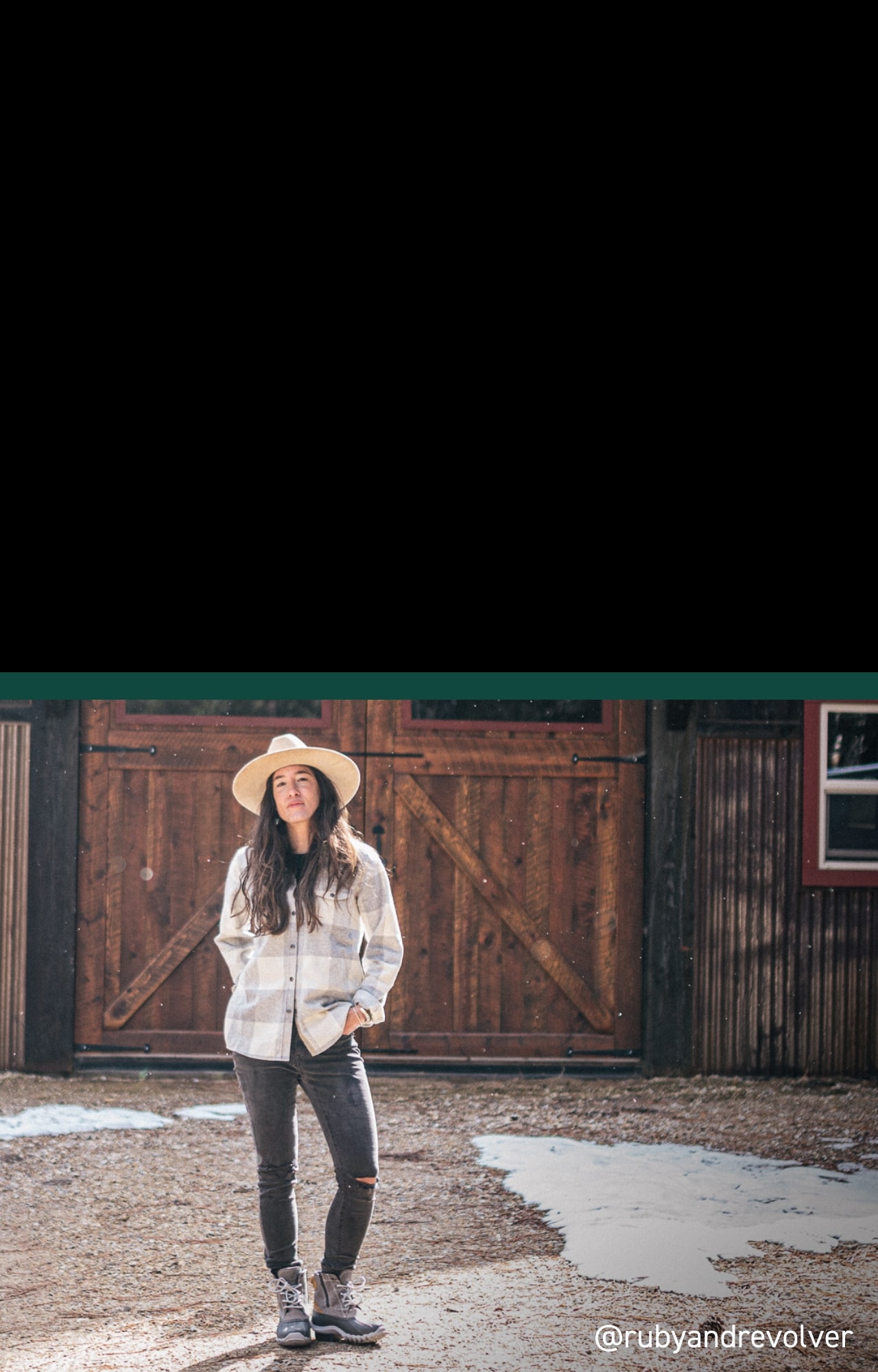 Person wearing Torrent boots stading in front of barn doors.