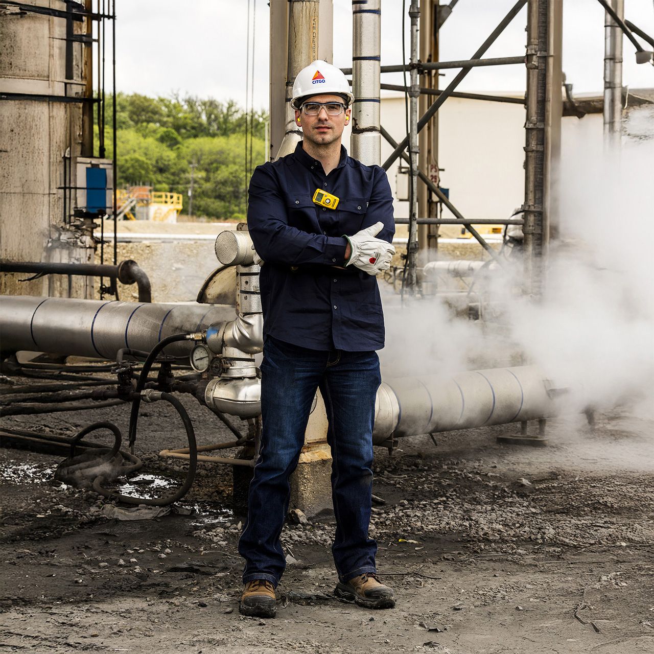 Standing beside steaming pipes wearing safey equipment and boots with the Infinity System.