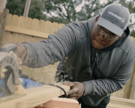 Student sawing lumber with a table saw.