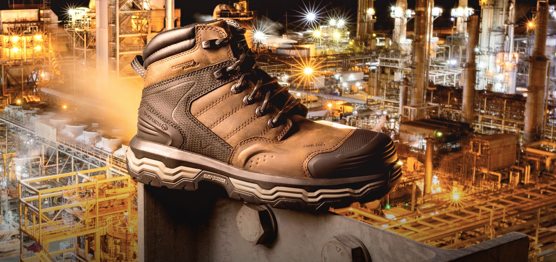 Boots on arid ground beside an oil derick.
