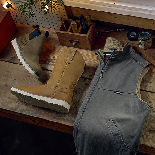 Boots and a vest on a workbench.