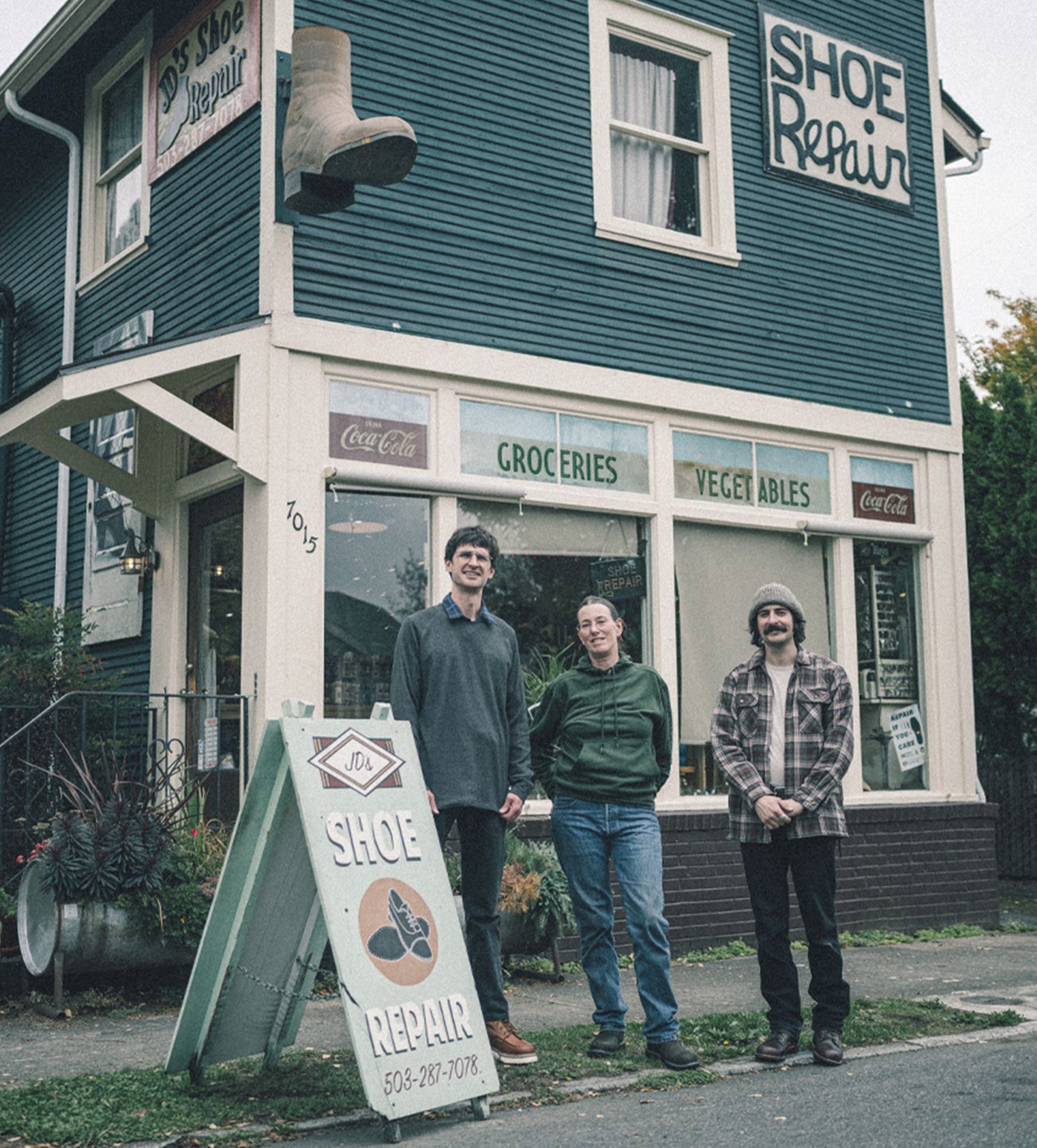 a group of people standing in front of a shoe repair store