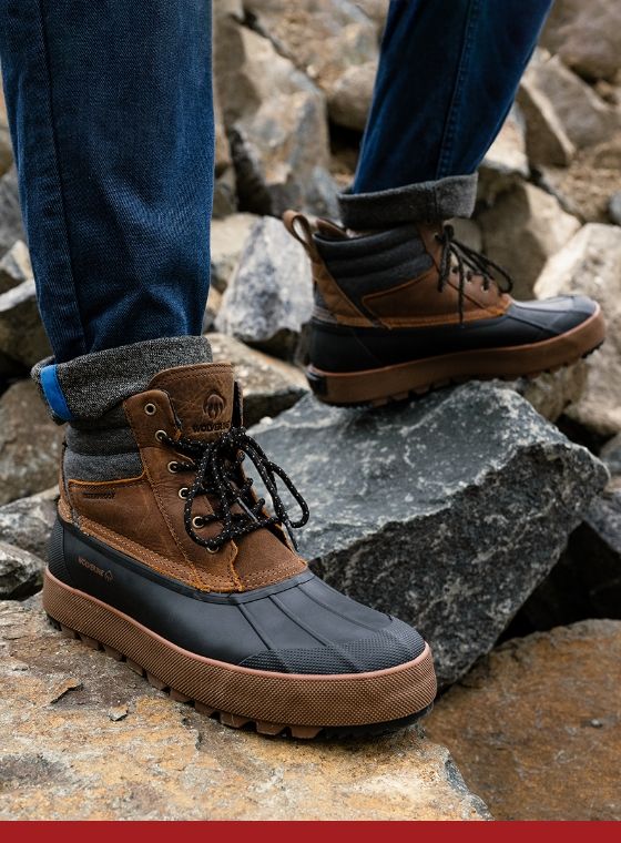 a person's feet in boots on rocks