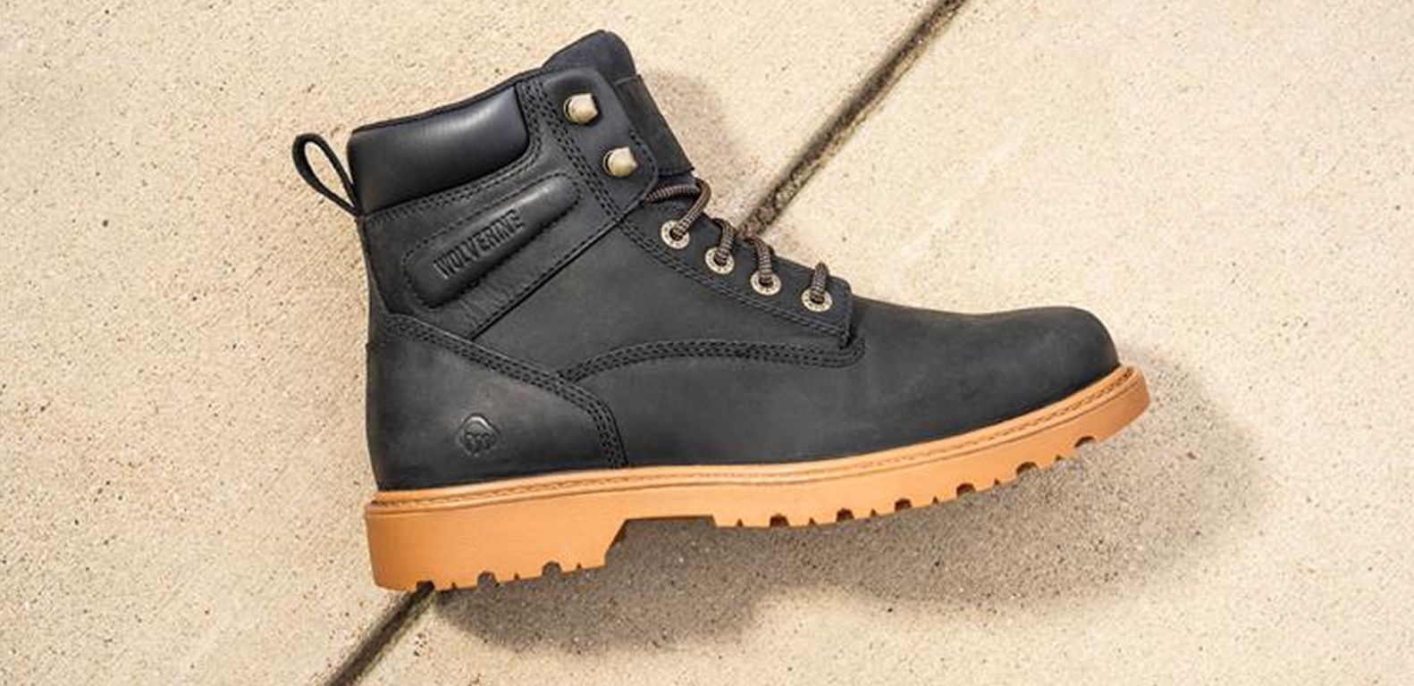 Black boot lying on concrete.