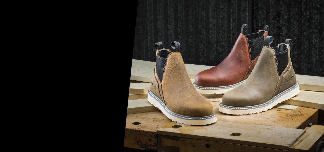 Various slip-on Wolverine boots on a work bench.