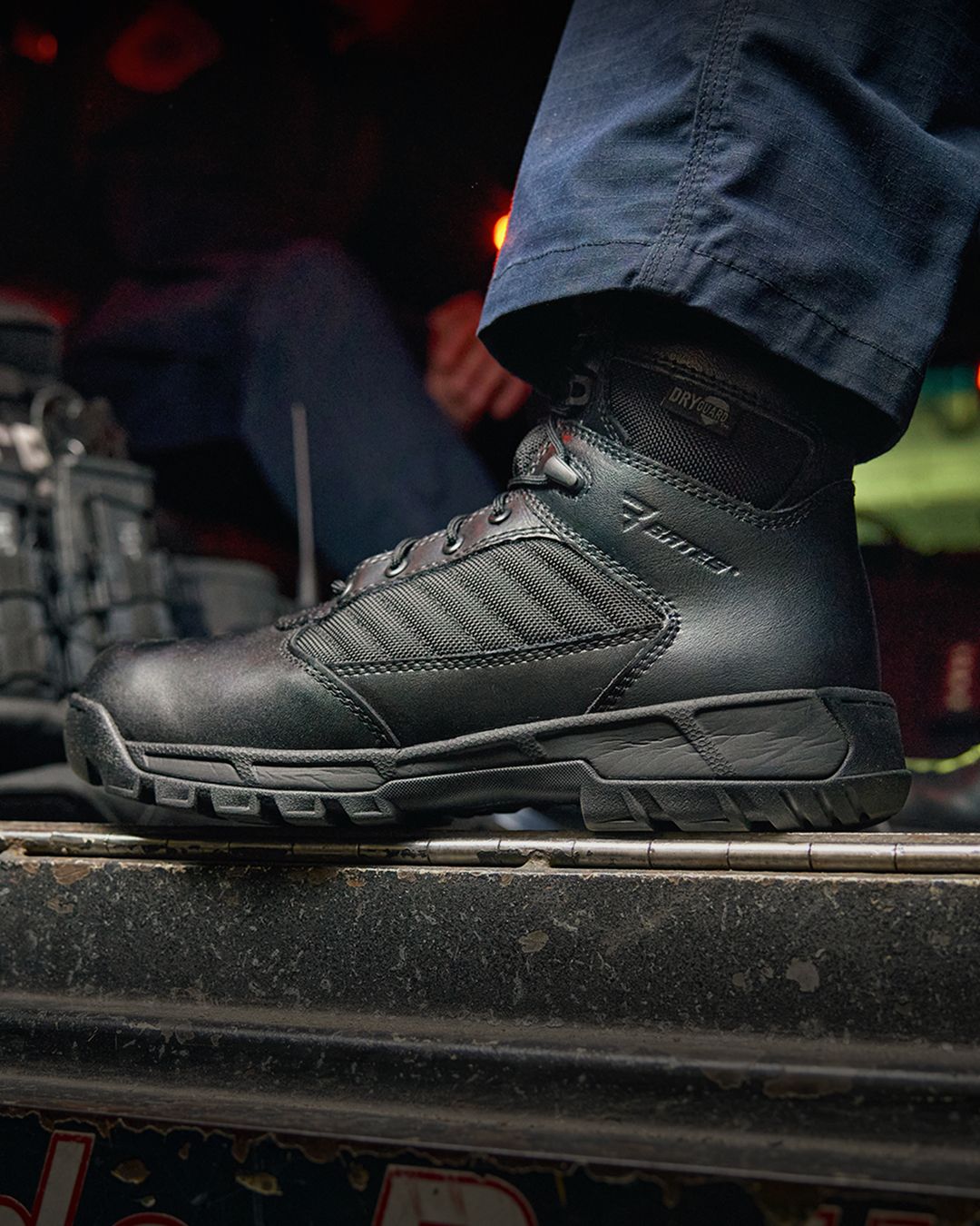 Black boots standing in the doorway of a vehicle.
