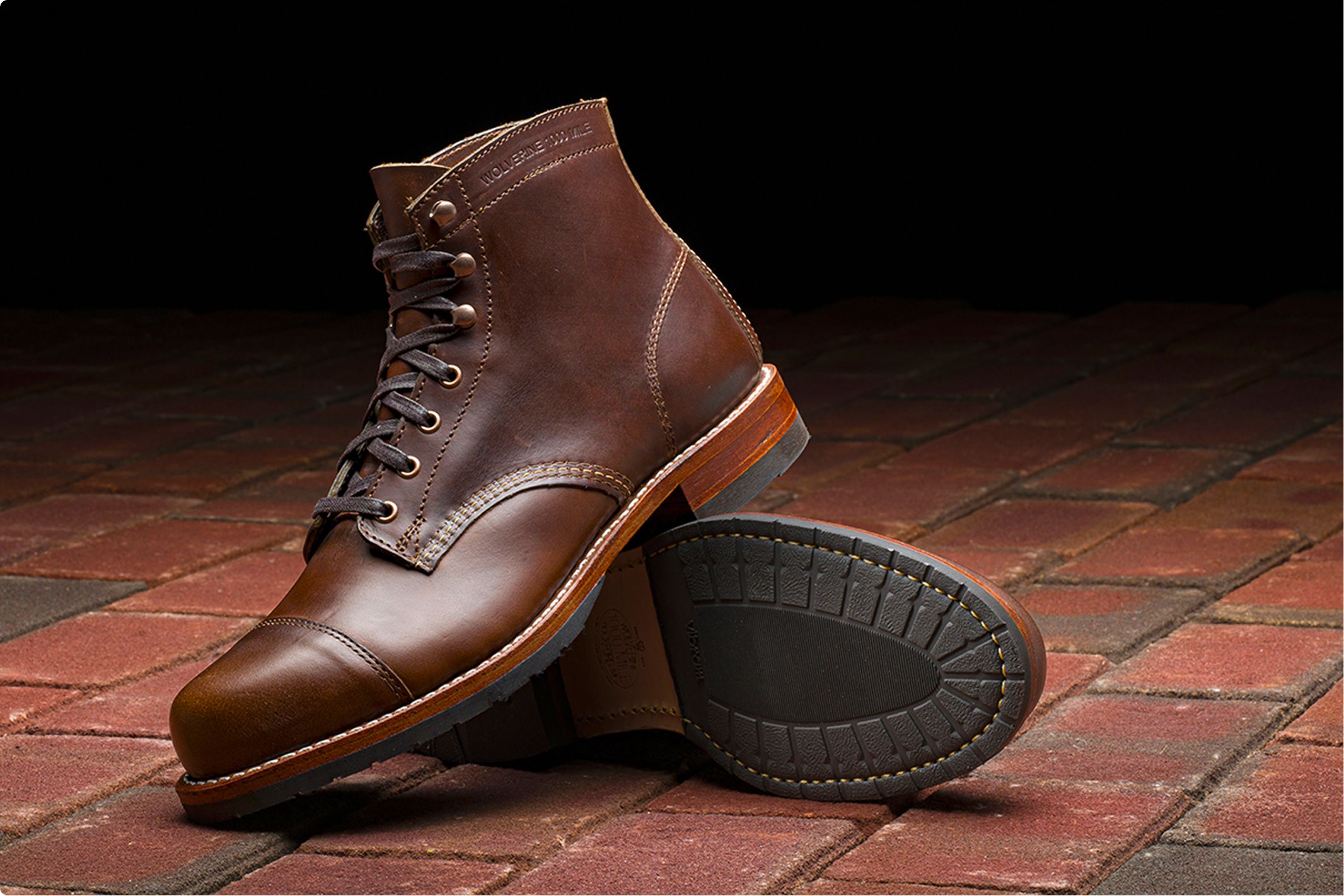 A pair of brown boots on a tile floor.
