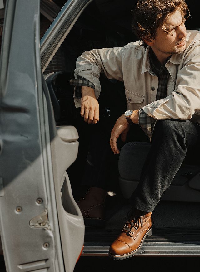 Worker trims a leather upper on a machine.