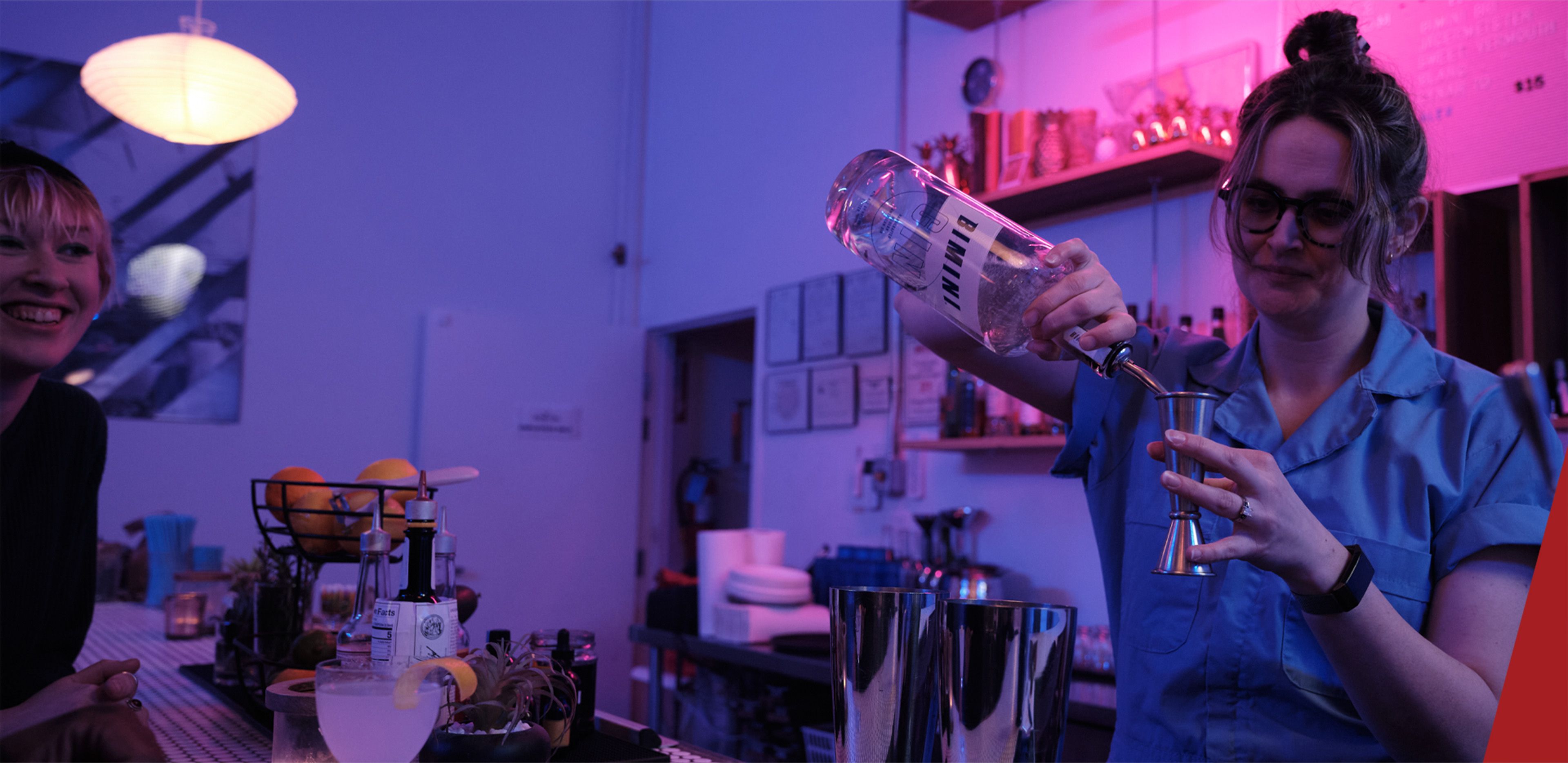 a person pouring a drink into a glass