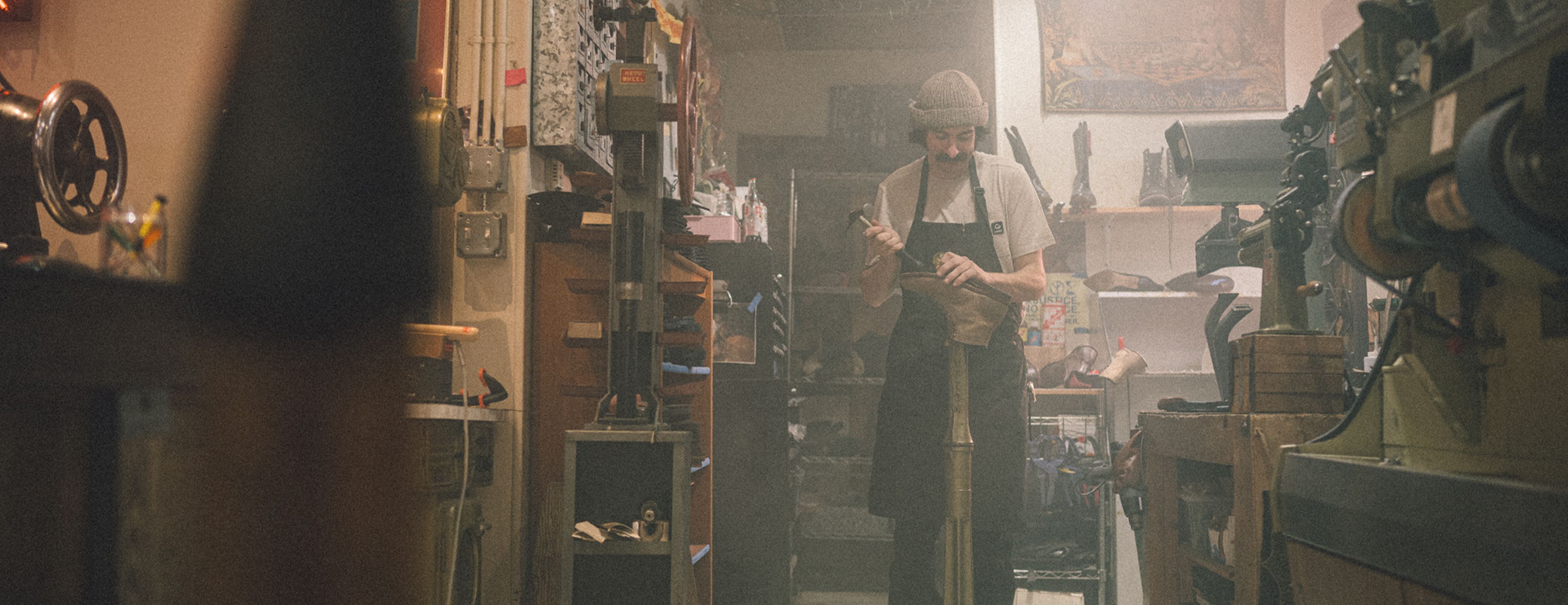 a man in a hat and apron working on a pipe