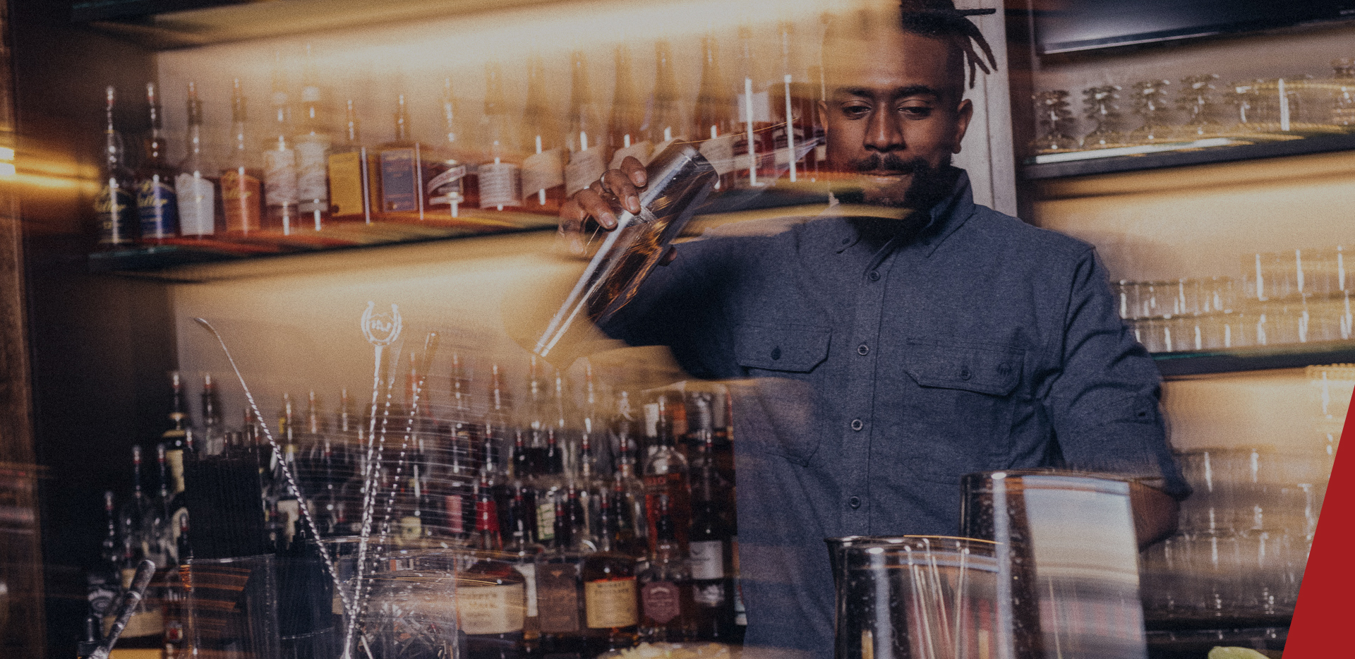 Chase Bardole sitting on the edge of a booth at his bar.