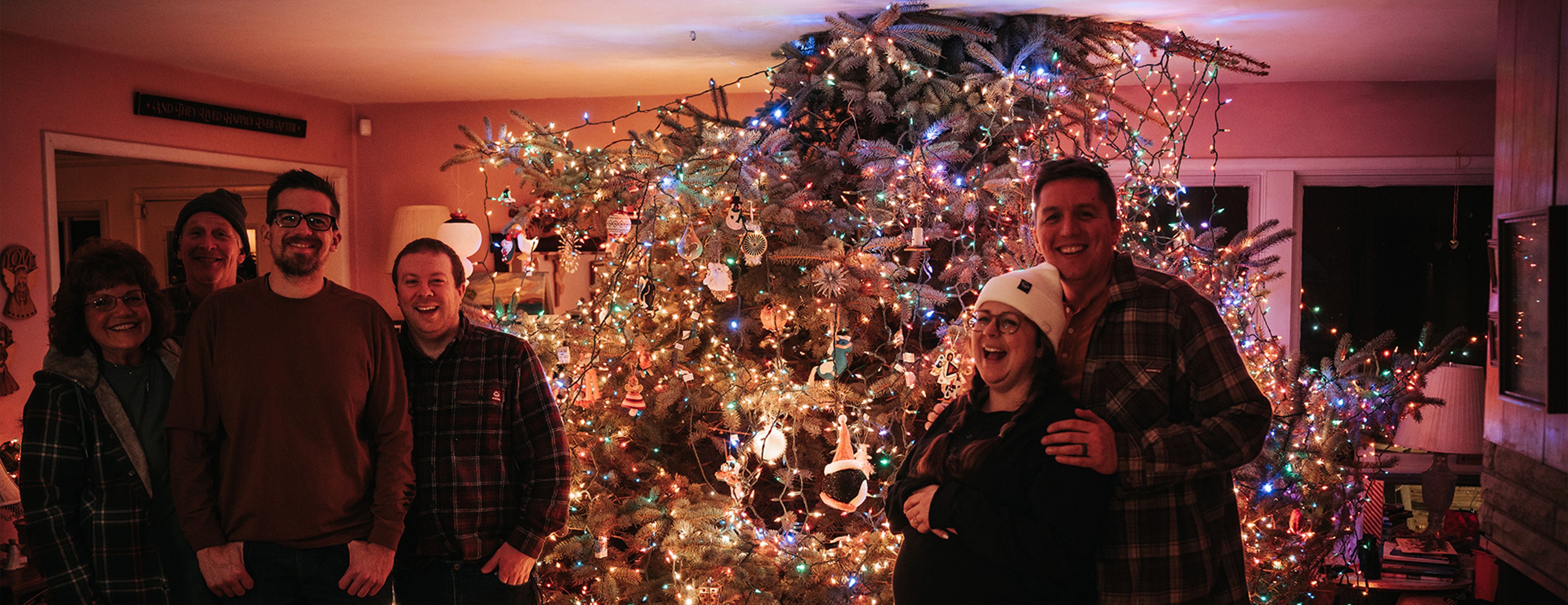 a group of people posing for a picture in front of a christmas tree
