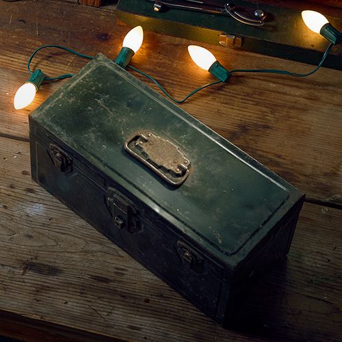 Toolbox on a workbench, surrounded by string lights.