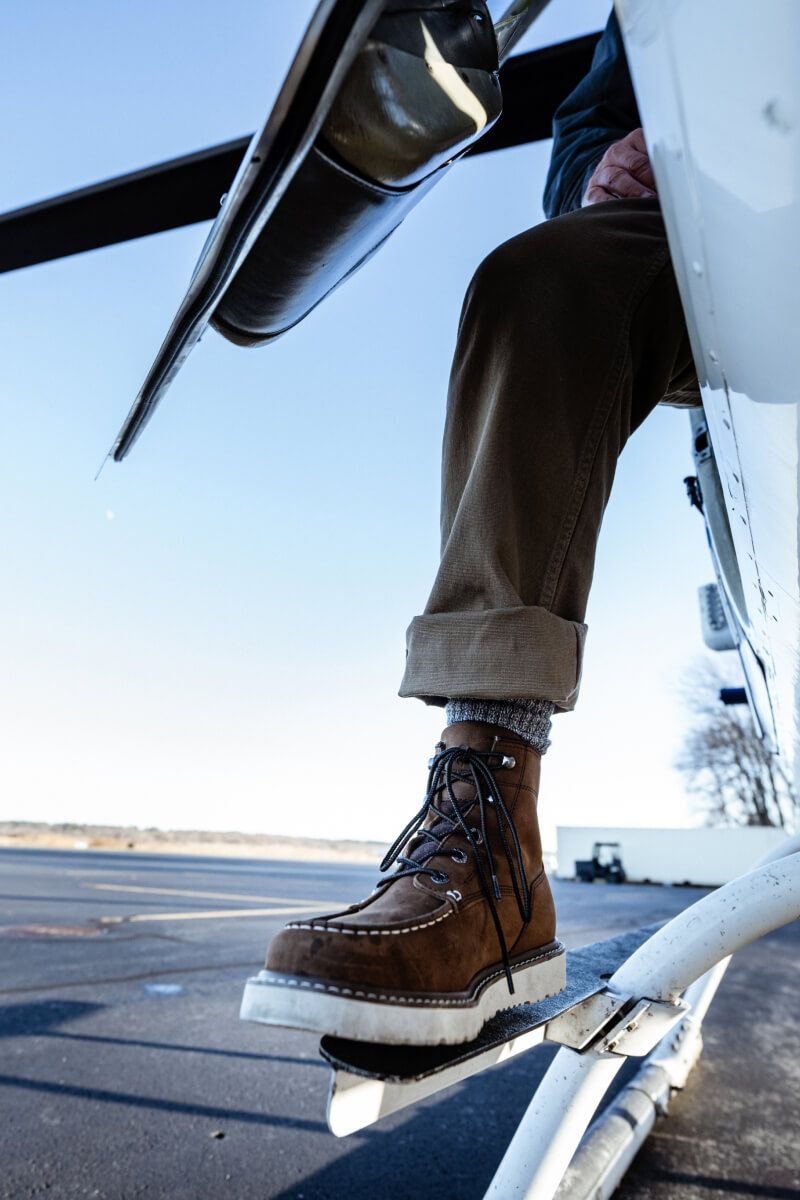 a person's feet in brown boots and brown pants