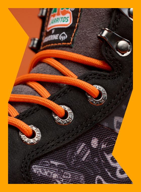 A close up of black boots with orange laces