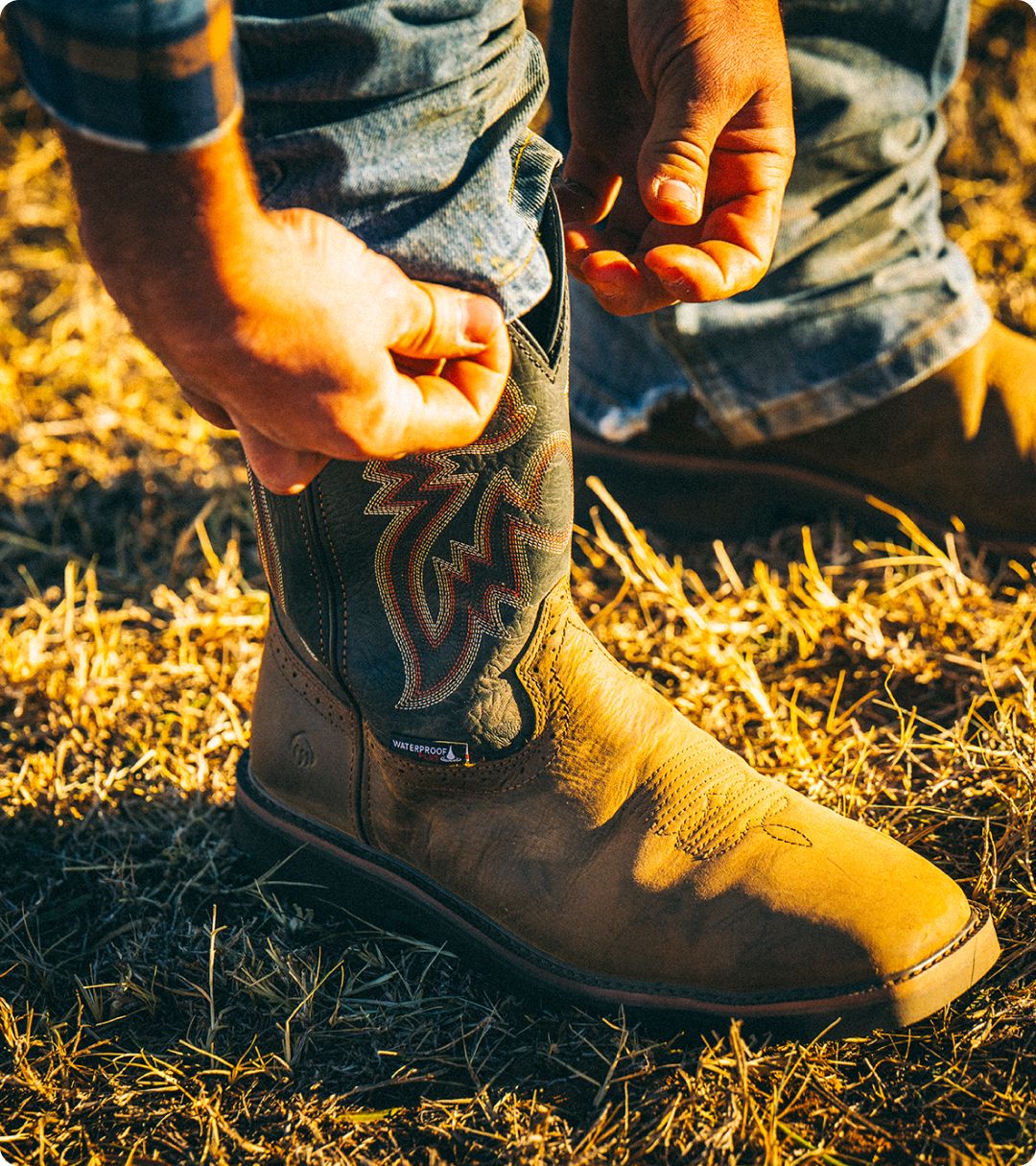 A pair of Black boots standing on grass.