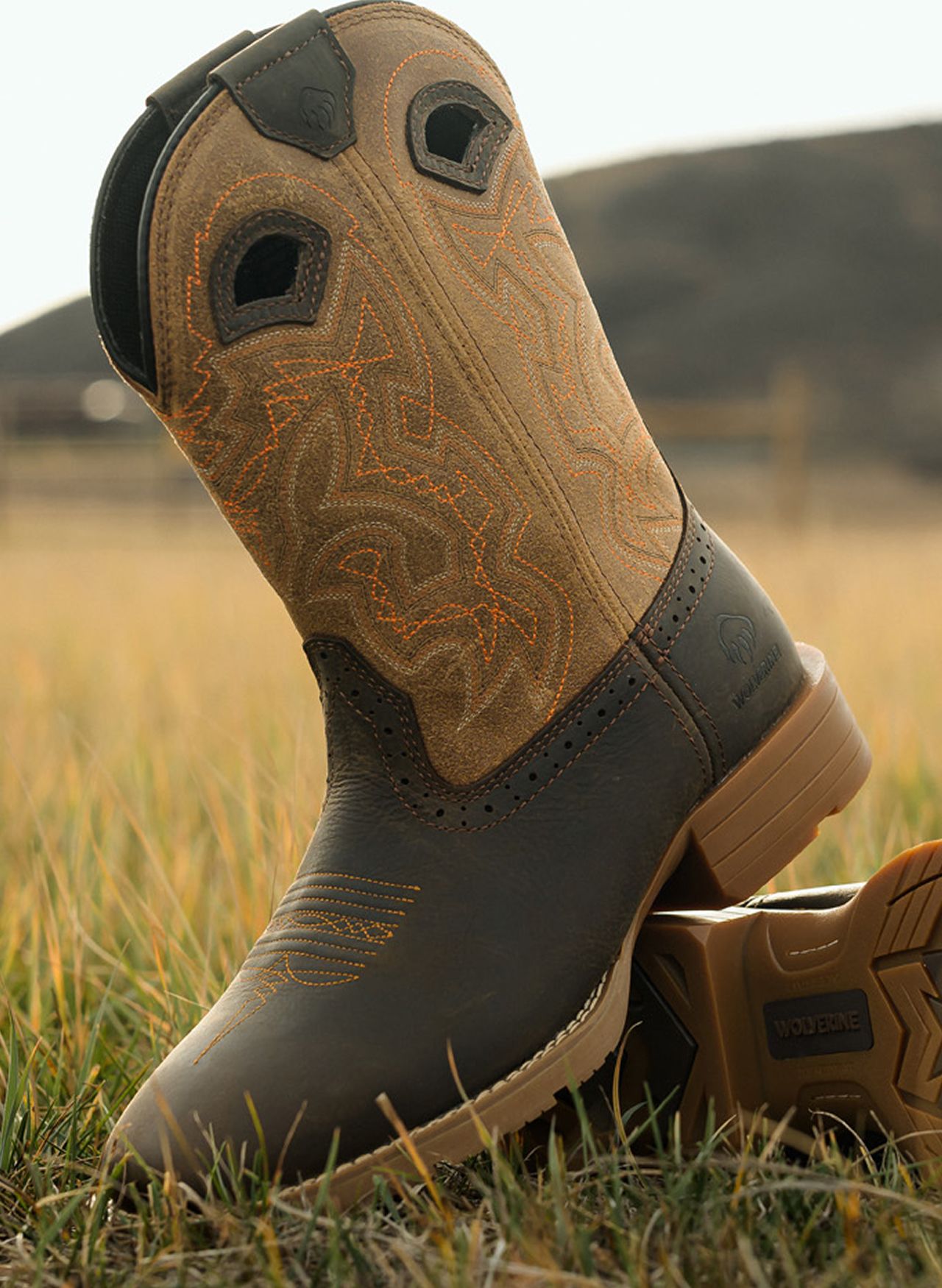 Brown western wolverine boots in grass outside.