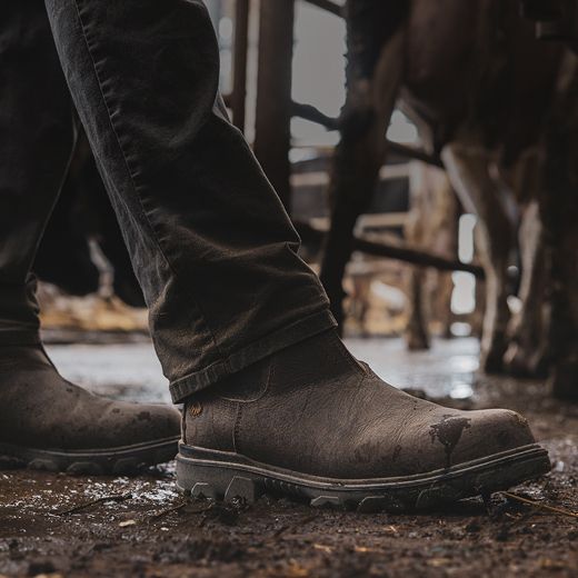 Boots walking through a wet cow shed.