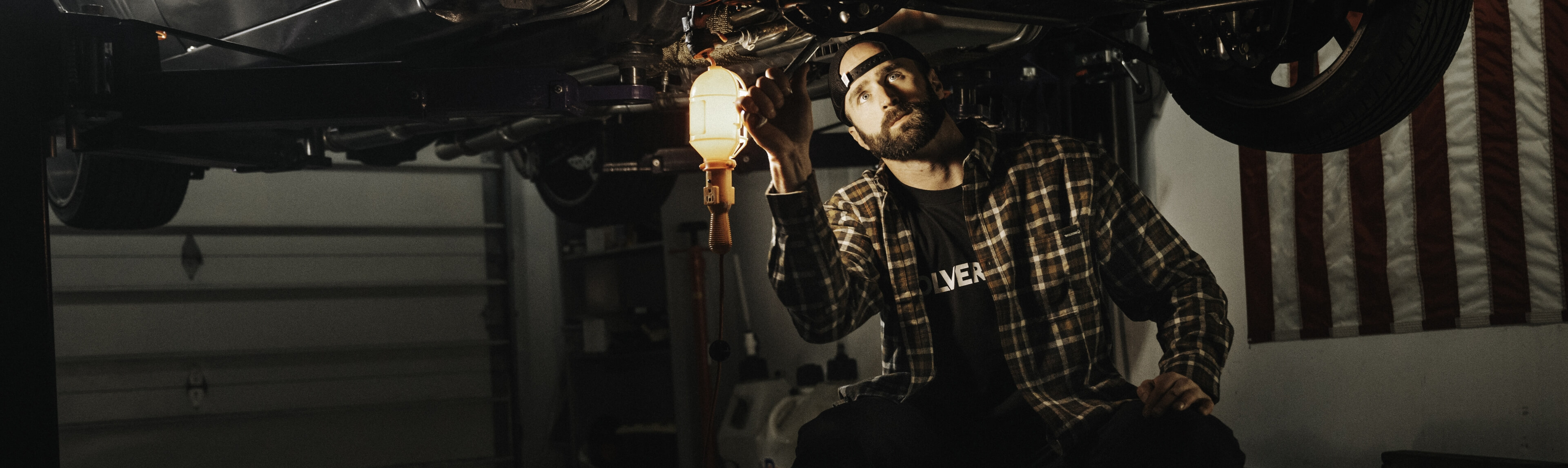 Mechanic working under lifted vehicle.