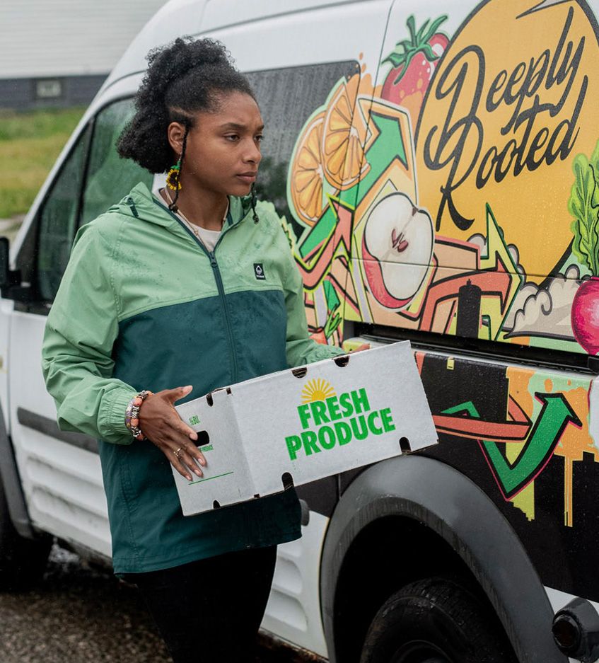 Dazmonique Carr carrying a box of produce.