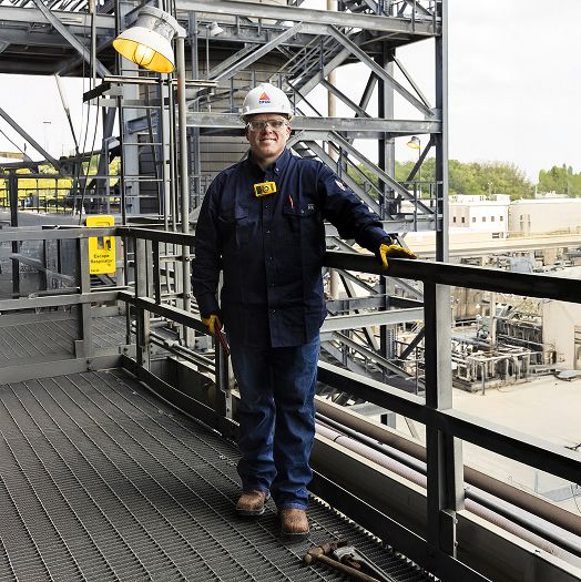 Standing beside steaming pipes wearing safey equipment and boots with the Infinity System.