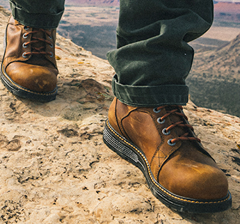 Person with boot walking on a mountain.