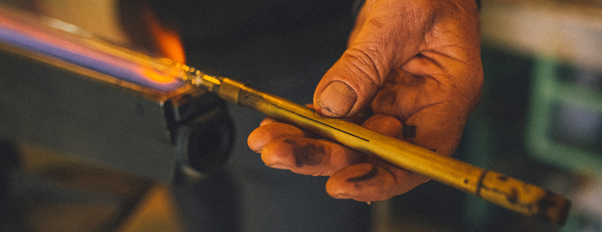 A close up of Matt shaping a glass tube.