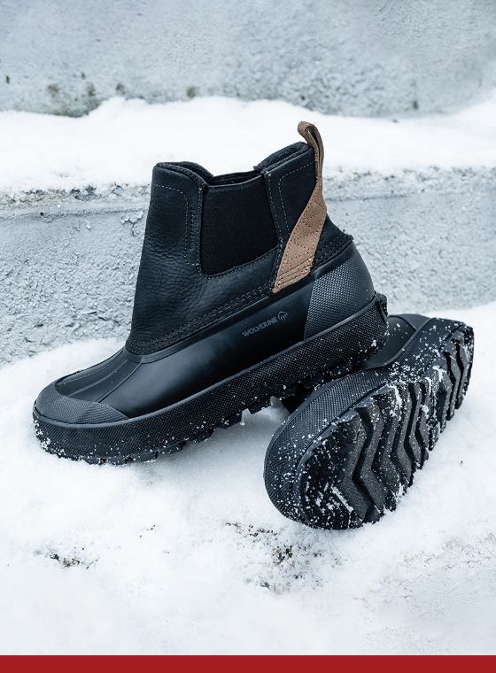 a pair of black boots on snow