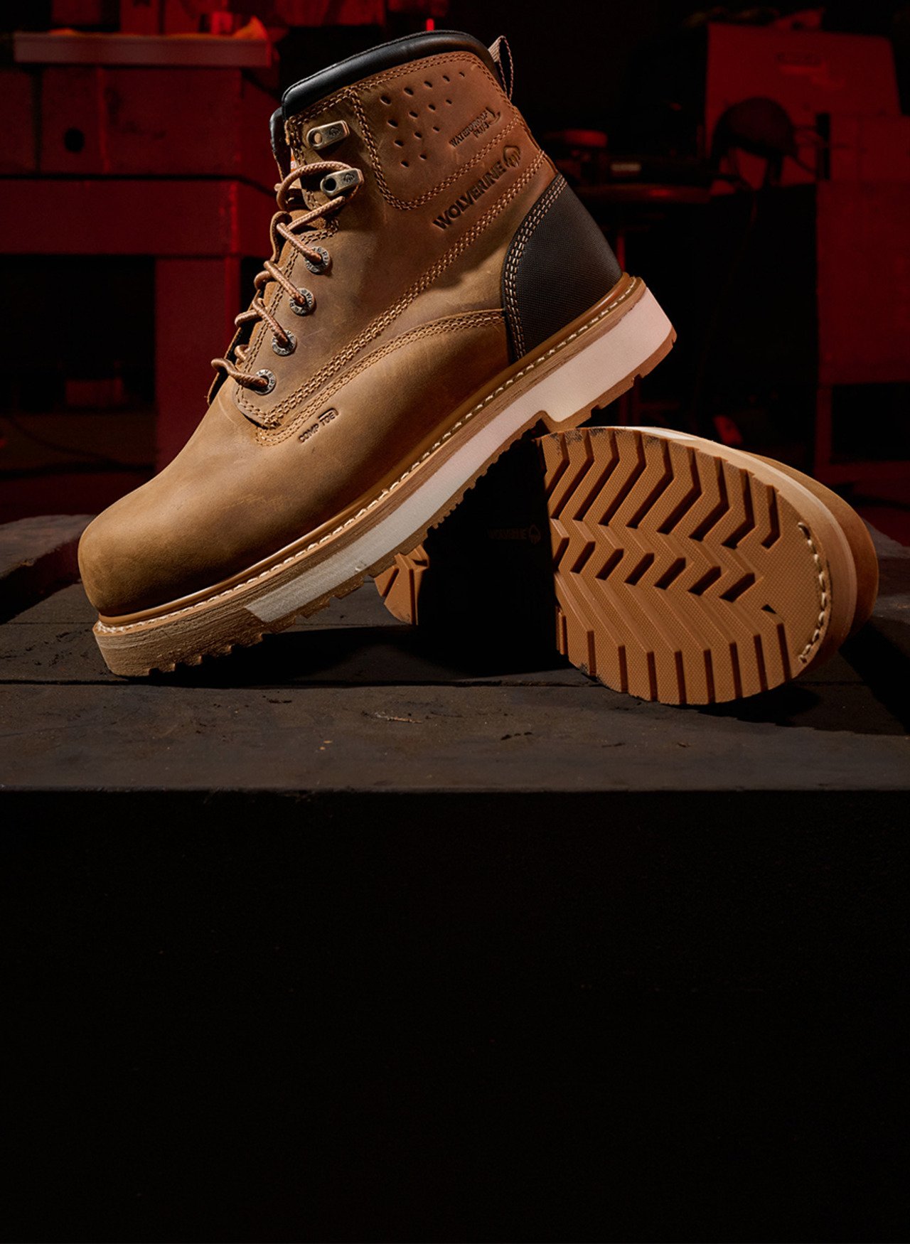 A Wolverine ReLoader boot with a 90 degree heel resting on a dark workbench.