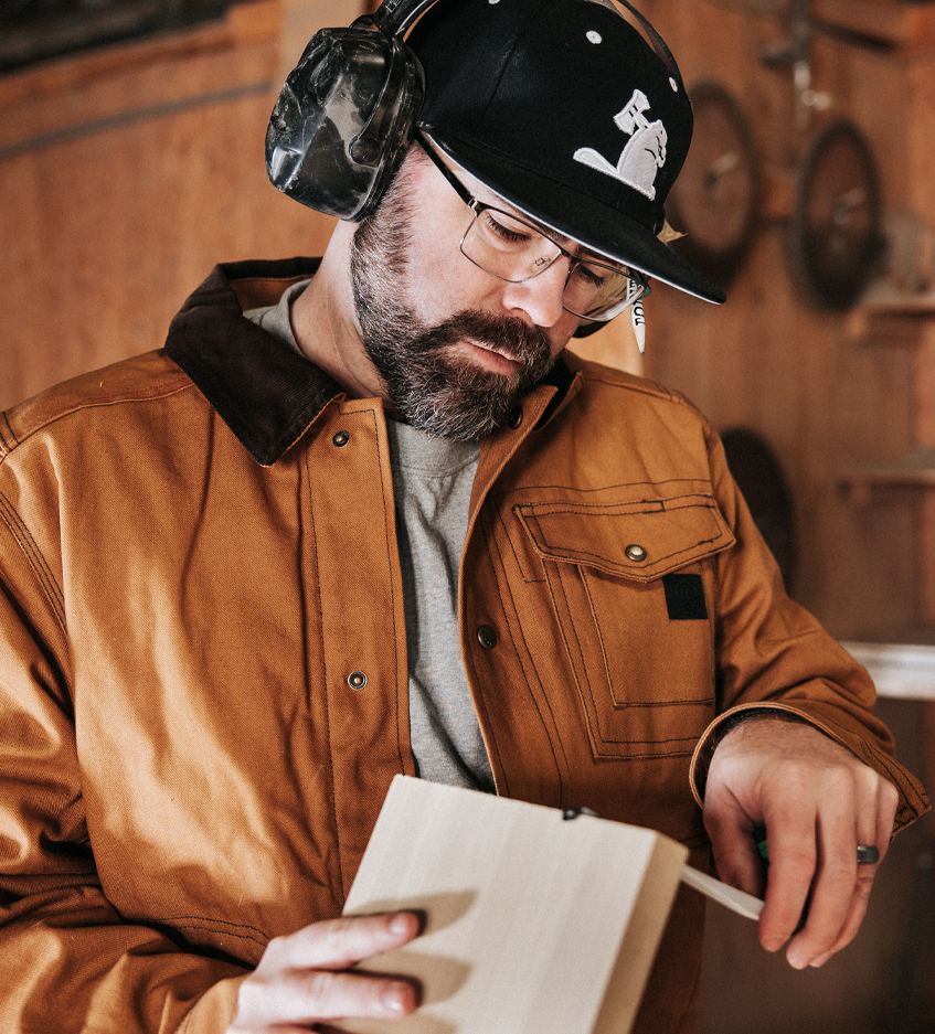 Jeremy Stokes measuring a wooden board.