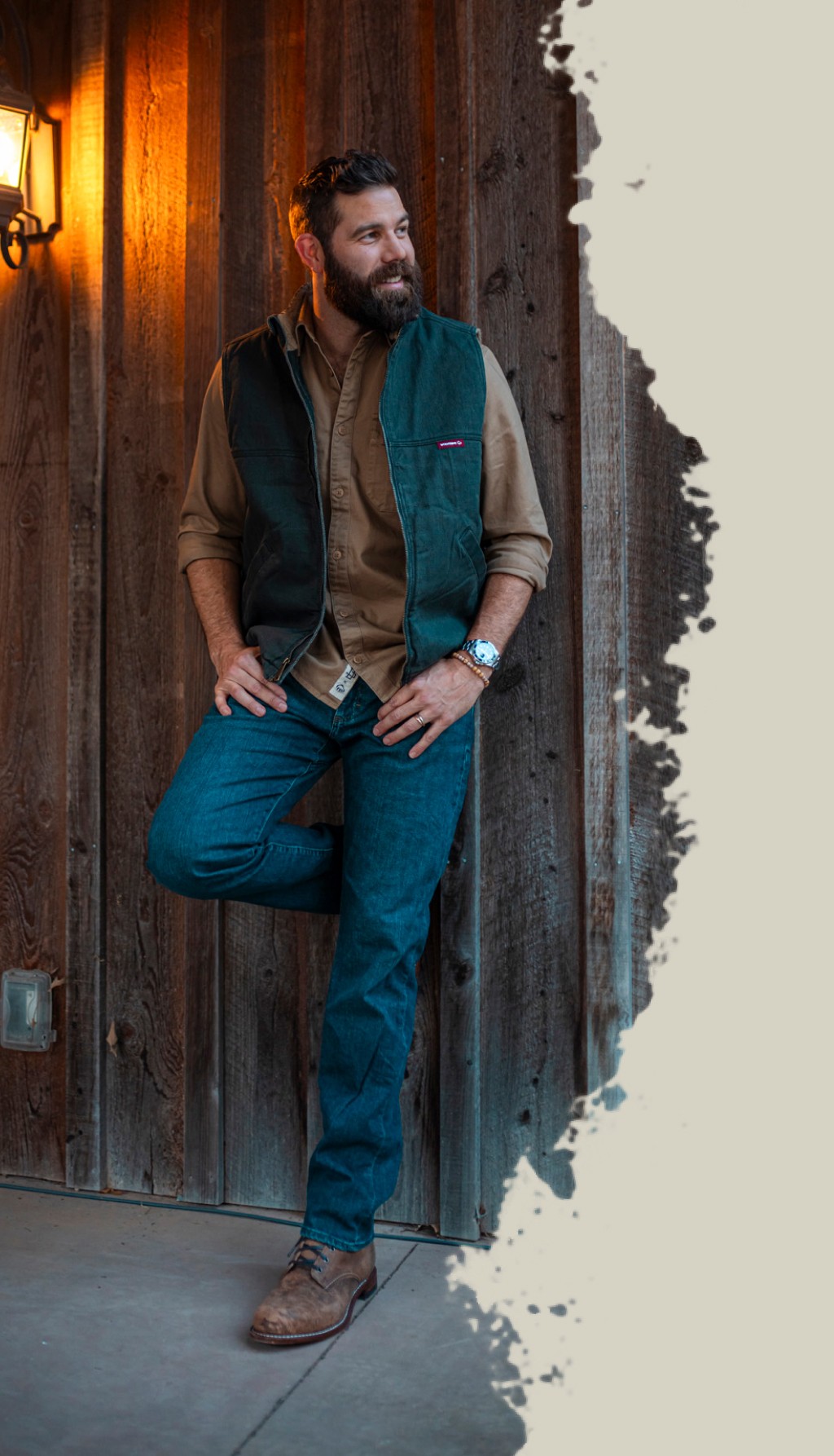 Jordan Davis leaning against a wood wall with a Wolverine vest on.